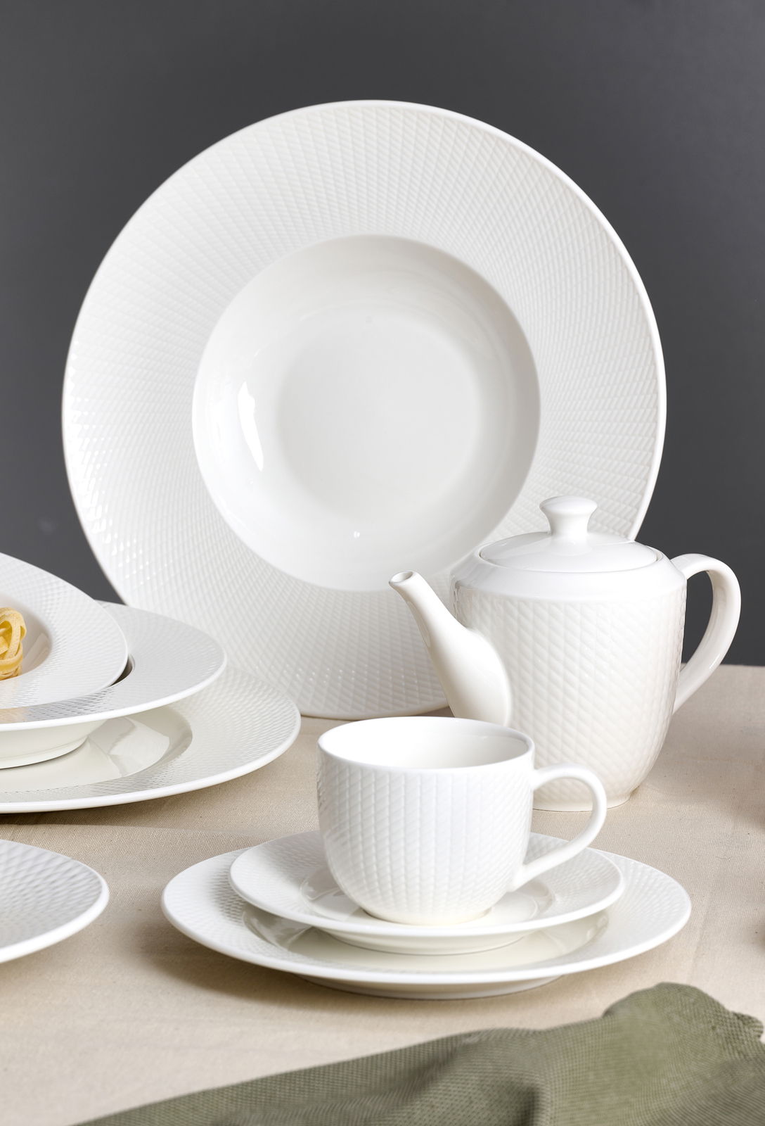 Ritzenhoff & Breker Koffieset, 18-delig SAPHIR Elegantes weißes Kaffeeset mit Tassen, Untertassen, Tellern und Teekanne in seitlicher Perspektive.