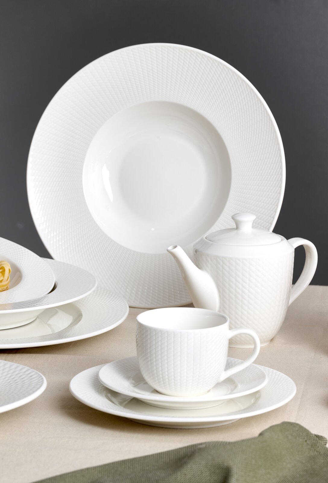Ritzenhoff & Breker Kaffeeset 18-tlg. SAPHIR Elegantes weißes Kaffeeset mit Tassen, Untertassen, Tellern und Teekanne in seitlicher Perspektive.