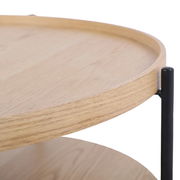 Nahaufnahme eines runden Couchtisches mit Holzplatte und schwarzem Metallgestell, seitliche Perspektive