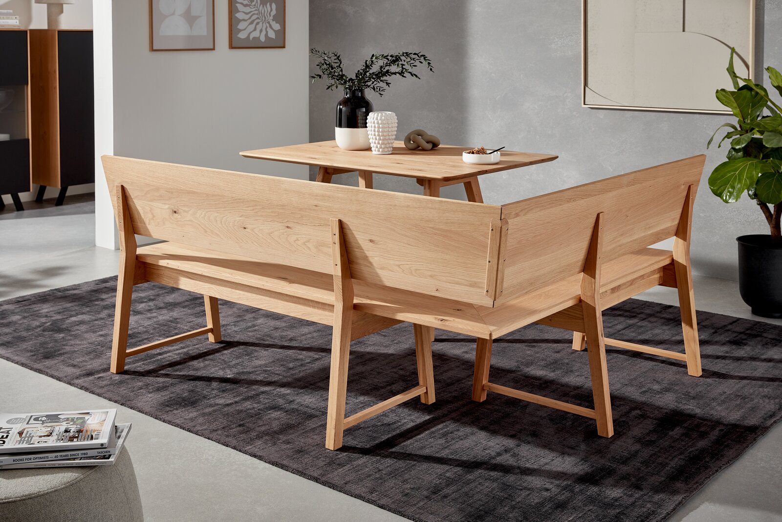 Holzeckbank in einem modernen Wohnzimmer, Rückansicht, mit Tisch und Dekorationen.