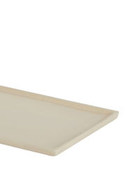 Ecke einer rechteckigen, cremefarbenen Schale aus seitlicher Perspektive