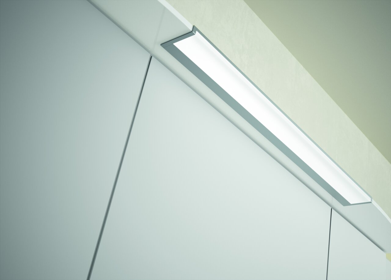 Nahaufnahme einer modernen Badezimmerleuchte über einem Spiegelschrank, von unten betrachtet.