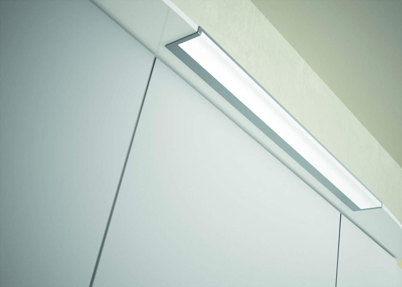 Nahaufnahme einer modernen Badezimmerleuchte über einem Spiegelschrank, von unten betrachtet.