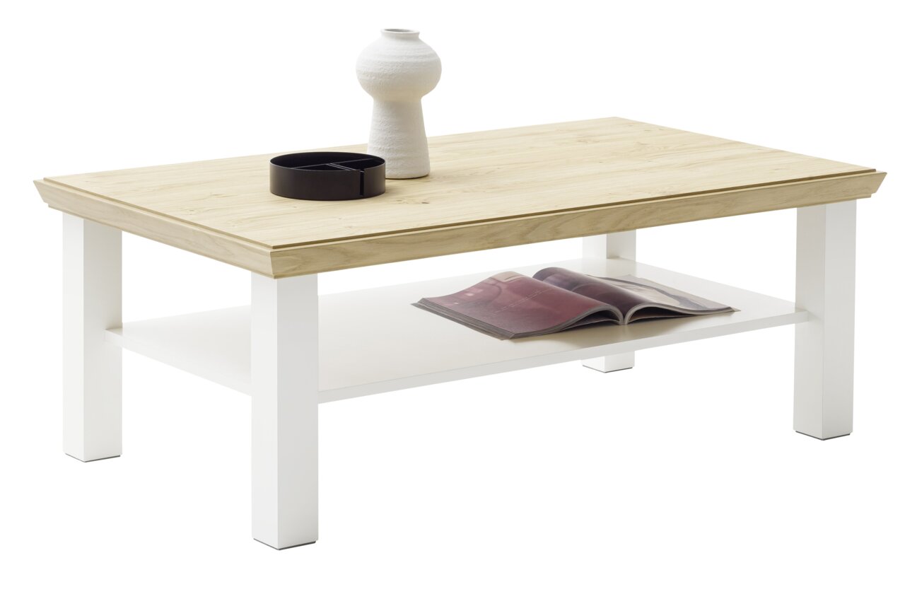Moderne salontafel van licht hout met witte poten, gezien vanaf de zijkant, versierd met een vaas en een schaal op het tafelblad, met daaronder een plank met een tijdschrift.