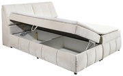 Boxspringbett VALENCIA in seitlicher Perspektive mit geöffneter Bettkastenfunktion und hellem Stoffbezug