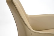 Close-up van een beige leren fauteuil, gezien vanaf de zijkant