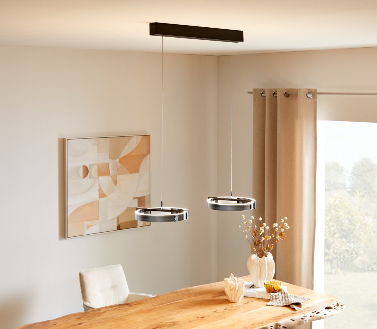 Dieter Knoll LED-Hängeleuchte Moderne LED-Hängeleuchte mit zwei runden Leuchtringen, von der Decke hängend über einem Esstisch, seitliche Perspektive.