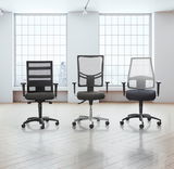 Drei moderne Drehstühle mit Netzrückenlehne und Armlehnen, frontal in einem hellen Raum mit großen Fenstern präsentiert.