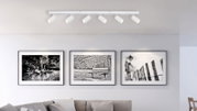 Moderne plafondspot met zes verstelbare spots in een woonkamer, gezien vanaf de zijkant.