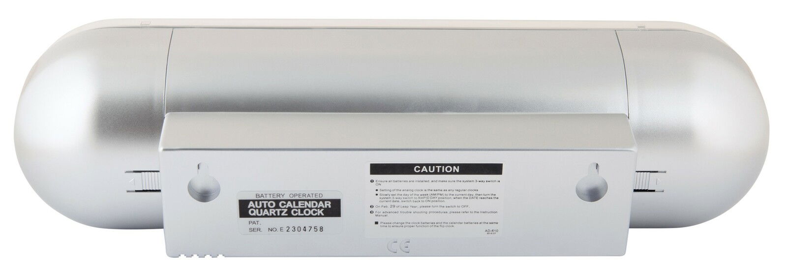 Rückansicht einer silbernen Tischuhr mit Batteriefach und Bedienungselementen.