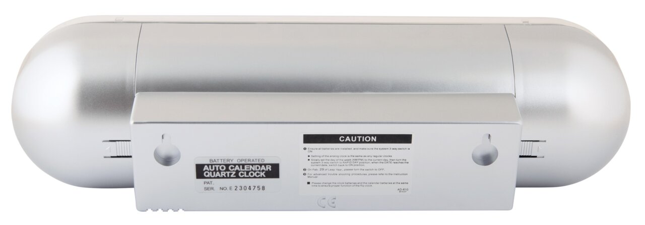 Rückansicht einer silbernen Tischuhr mit Batteriefach und Bedienungselementen.