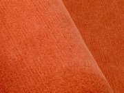Nahaufnahme eines orangefarbenen Wollteppichs mit weicher Textur.