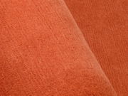 Nahaufnahme eines orangefarbenen Wollteppichs mit weicher Textur.