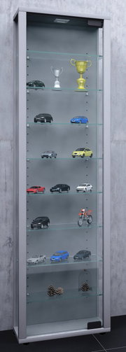 Hohe Glasvitrine mit Aluminiumrahmen und Glaseinlegeböden, bestückt mit Modellautos, Pokalen und Dekoration; frontale Ansicht leicht von links.