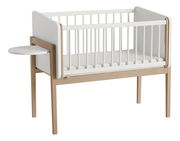 Beistellbett aus Holz mit weißem Gitter und seitlichem Tablar, seitliche Perspektive