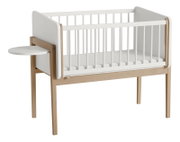 Beistellbett aus Holz mit weißem Gitter und seitlichem Tablar, seitliche Perspektive