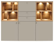 Frontale Ansicht eines modernen Highboards mit grauen Türen und Schubladen, flankiert von offenen Holzregalen mit integrierter Beleuchtung.