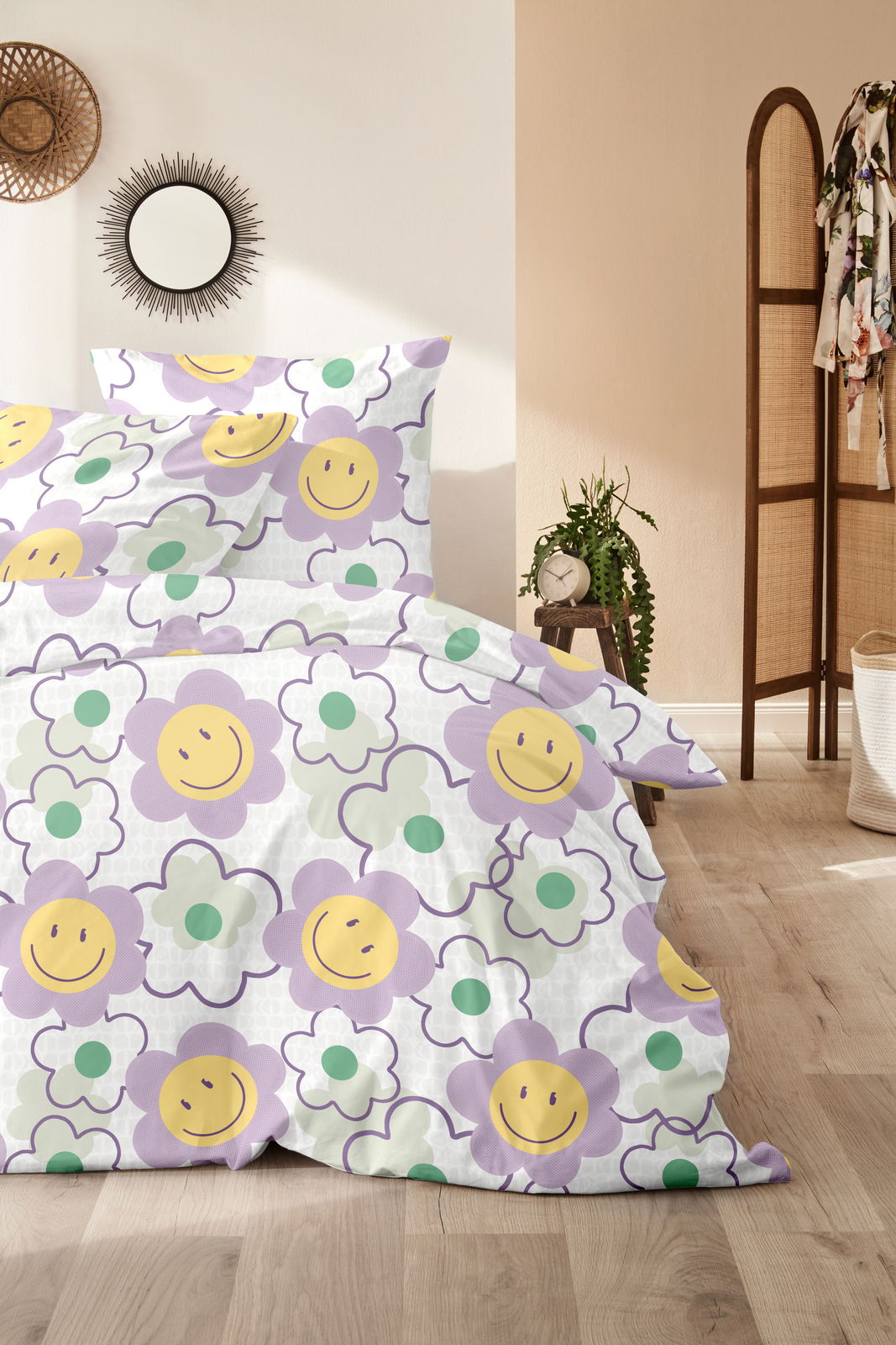 Bettwäsche mit fröhlichem Blumenmuster in Lila, Gelb und Grün, fotografiert aus einer seitlichen Perspektive im Schlafzimmer.