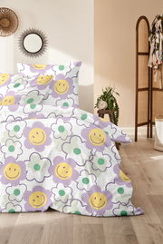 Bettwäsche mit fröhlichem Blumenmuster in Lila, Gelb und Grün, fotografiert aus einer seitlichen Perspektive im Schlafzimmer.