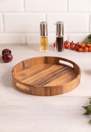 Rundes Holztablett mit Griffen, auf einem Tisch in einer Küchenumgebung, aus der Perspektive von schräg oben fotografiert.