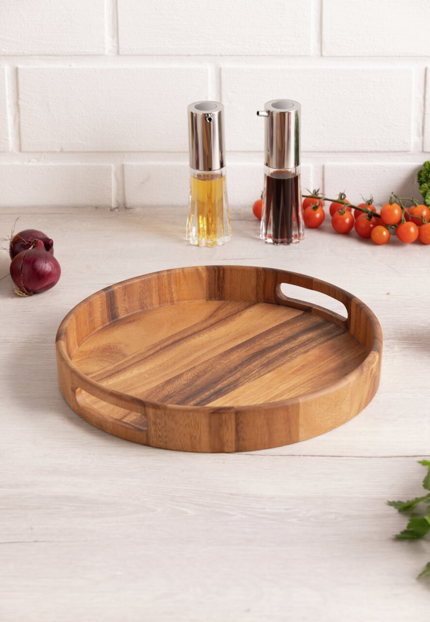Rundes Holztablett mit Griffen, auf einem Tisch in einer Küchenumgebung, aus der Perspektive von schräg oben fotografiert.