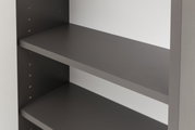 Nahaufnahme eines grauen Hängeschranks mit verstellbaren Regalböden, seitliche Perspektive