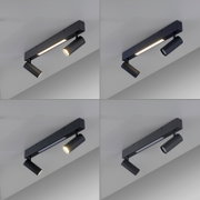 Schwarze, moderne Deckenleuchte mit rechteckiger Schiene, integriertem LED-Lichtband und zwei verstellbaren Spotstrahlern, fotografiert in schräger Untersicht (Blick von unten auf die Decke).
