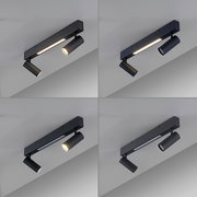 Schwarze, moderne Deckenleuchte mit rechteckiger Schiene, integriertem LED-Lichtband und zwei verstellbaren Spotstrahlern, fotografiert in schräger Untersicht (Blick von unten auf die Decke).