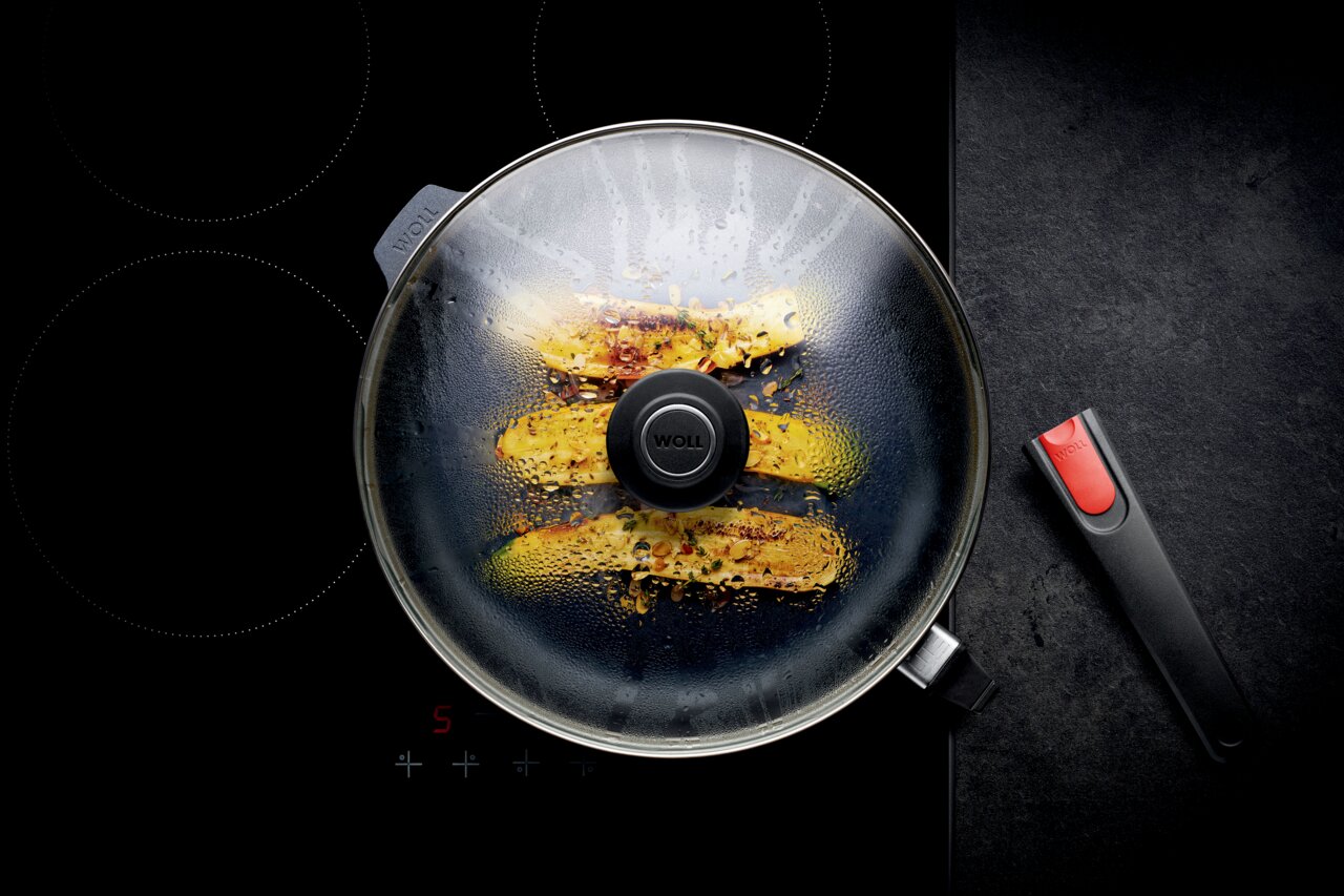 Guss-Hochrandpfanne 32cm Diamo mit Glasdeckel, von oben fotografiert, auf einem Herd mit abnehmbarem Griff.