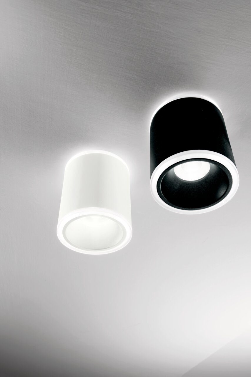 Zwei zylindrische LED-Aufbauspots in Schwarz und Weiß, von unten betrachtet, an der Decke montiert.