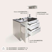 Kücheninsel mit schwarzer Arbeitsplatte, mehreren Schubladen und einem offenen Schrank, Perspektive von vorne rechts.