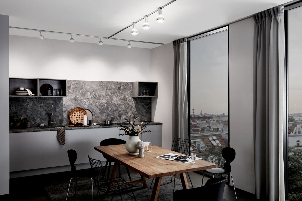 PAULMANN Ceiling Socket URAIL Moderne Küche mit URAIL Deckenleuchten von PAULMANN, Perspektive von der Seite mit Blick auf den Esstisch und die Fensterfront.