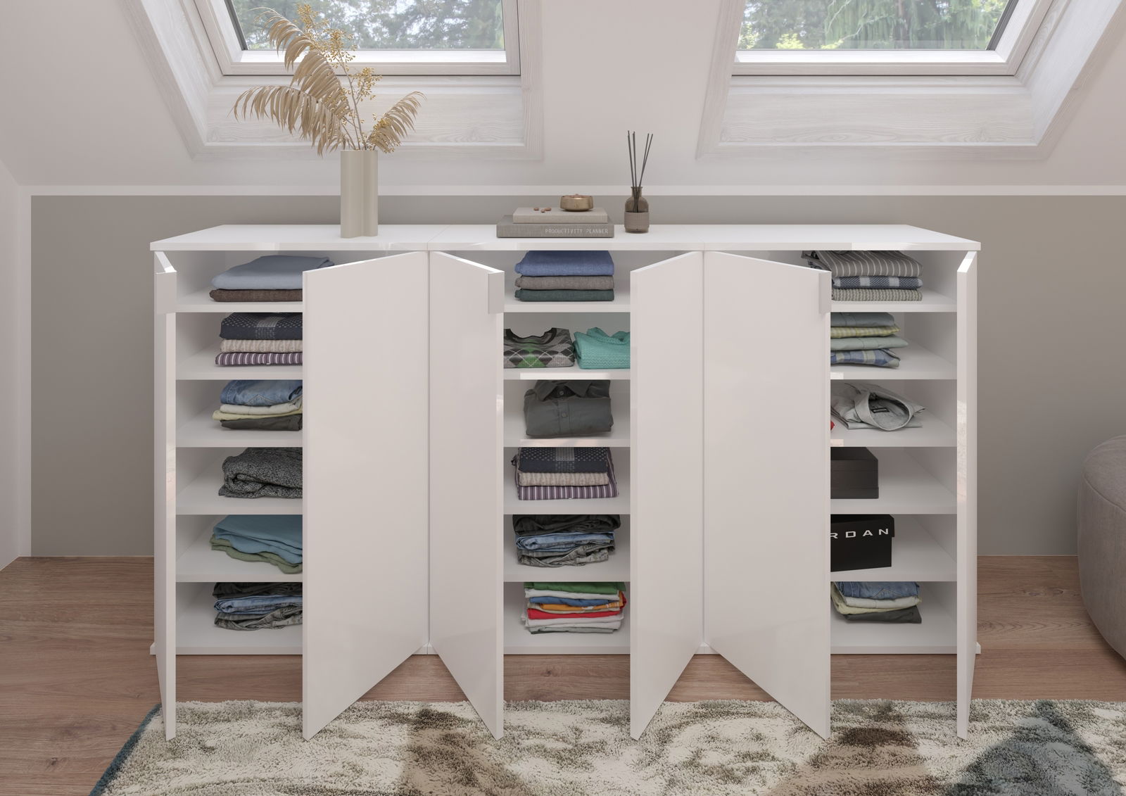 Weiße Garderobenkombination mit offenen Türen, gefüllt mit gefalteter Kleidung, aus der Frontalperspektive fotografiert. Oberhalb befinden sich Dekorationen und Bücher unter einem Dachfenster.