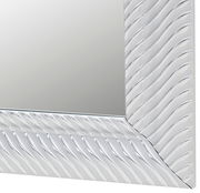 Nahaufnahme eines Spiegels mit wellenförmigem Rahmen, perspektivisch von der Seite aufgenommen.