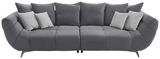 Graues Big-Sofa L mit mehreren Kissen, frontal betrachtet.