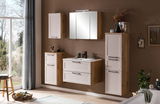 Modernes Waschtisch-Set in Holzoptik mit weißen Fronten, bestehend aus einem Waschbecken mit Unterschrank, einem Spiegelschrank und zusätzlichen Hängeschränken, aus der Perspektive eines hellen Badezimmers mit Blick auf den Garten.