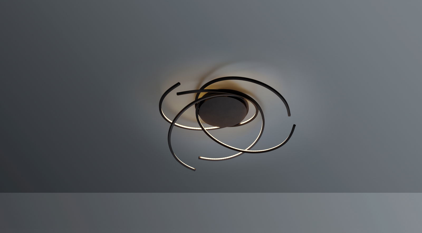 Moderne Deckenleuchte SPACE mit geschwungenen LED-Streifen, von unten betrachtet.