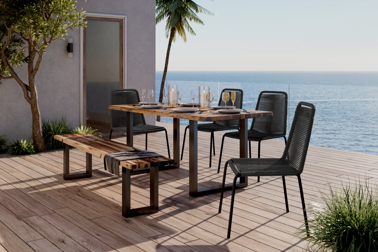 Moderner Stapelstuhl auf einer Terrasse mit Meerblick, neben einem Holztisch und einer Bank, aus seitlicher Perspektive.