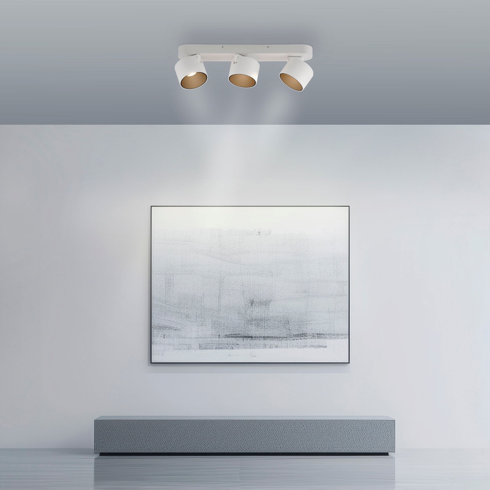Deckenansicht eines modernen LED-Spots mit drei verstellbaren Leuchten, die ein Kunstwerk an der Wand beleuchten.
