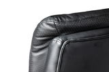 Nahaufnahme der Rückseite eines schwarzen Chefsessels aus Leder mit gepunktetem Muster, seitliche Perspektive