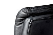 Nahaufnahme der Rückseite eines schwarzen Chefsessels aus Leder mit gepunktetem Muster, seitliche Perspektive