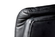 Nahaufnahme der Rückseite eines schwarzen Chefsessels aus Leder mit gepunktetem Muster, seitliche Perspektive