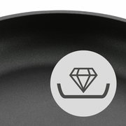 Nahaufnahme einer Pfanne mit Antihaftbeschichtung und einem Symbol für Haltbarkeit, seitliche Perspektive.