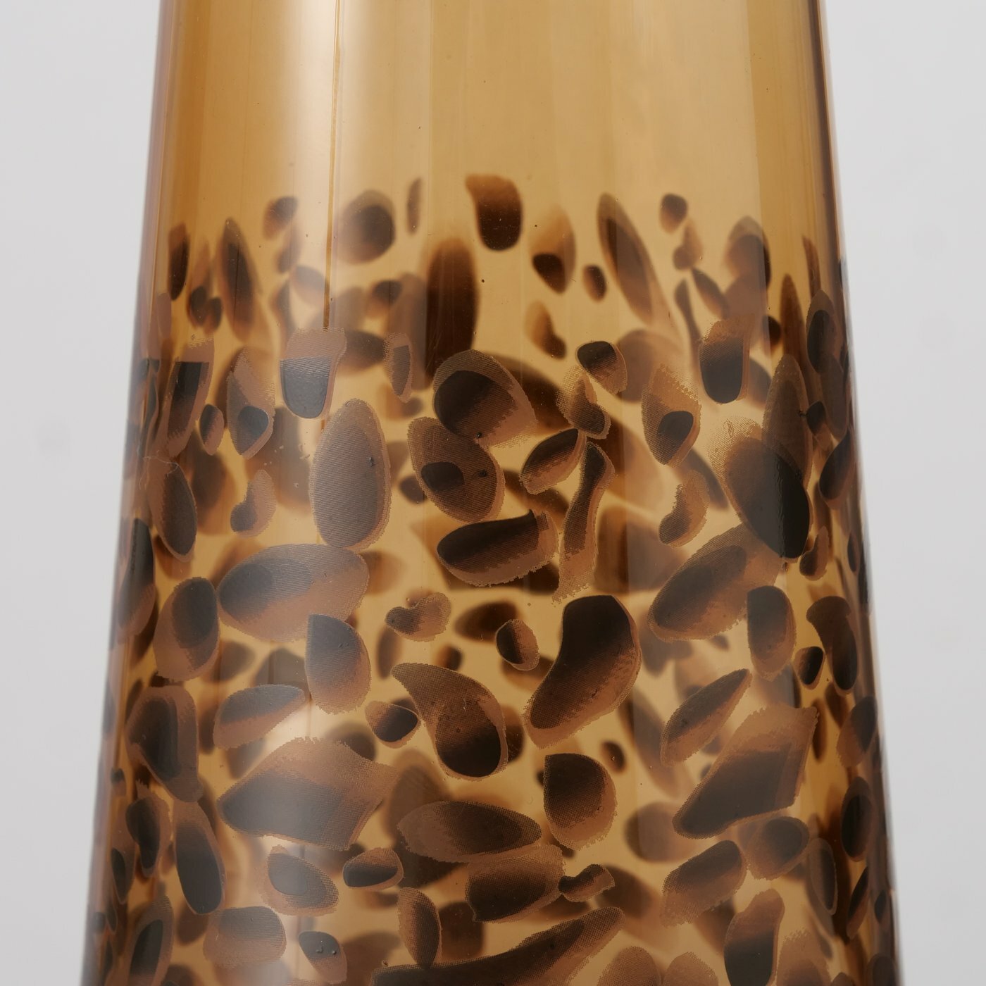 Nahaufnahme einer Karaffe mit braunem, gesprenkeltem Muster auf transparentem Glas.