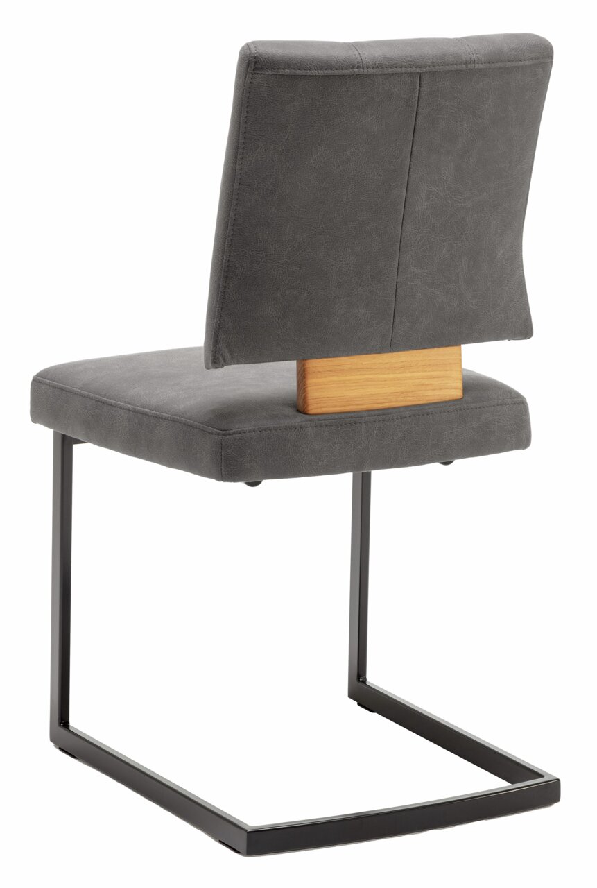 Achterkant van een zweefstoel met grijze bekleding en een zwart metalen frame, met een houten detail op de rugleuning.