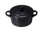Zwarte mini-cocotte gezien van bovenaf, met twee handvatten en een deksel, licht van bovenaf gefotografeerd in perspectief.