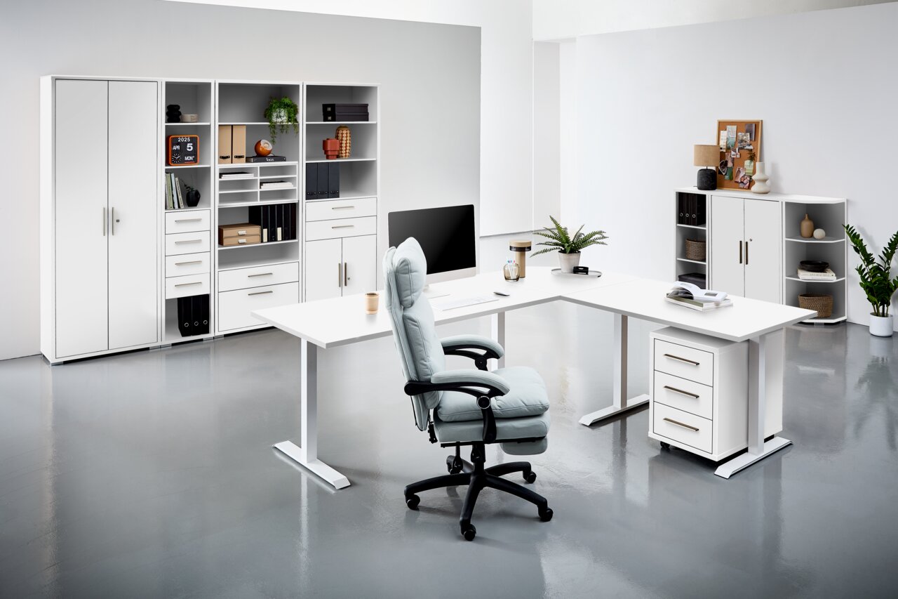 Moderne Büroumgebung mit weißen Schreibtischen, Regalen und einem ergonomischen Bürostuhl, seitliche Perspektive