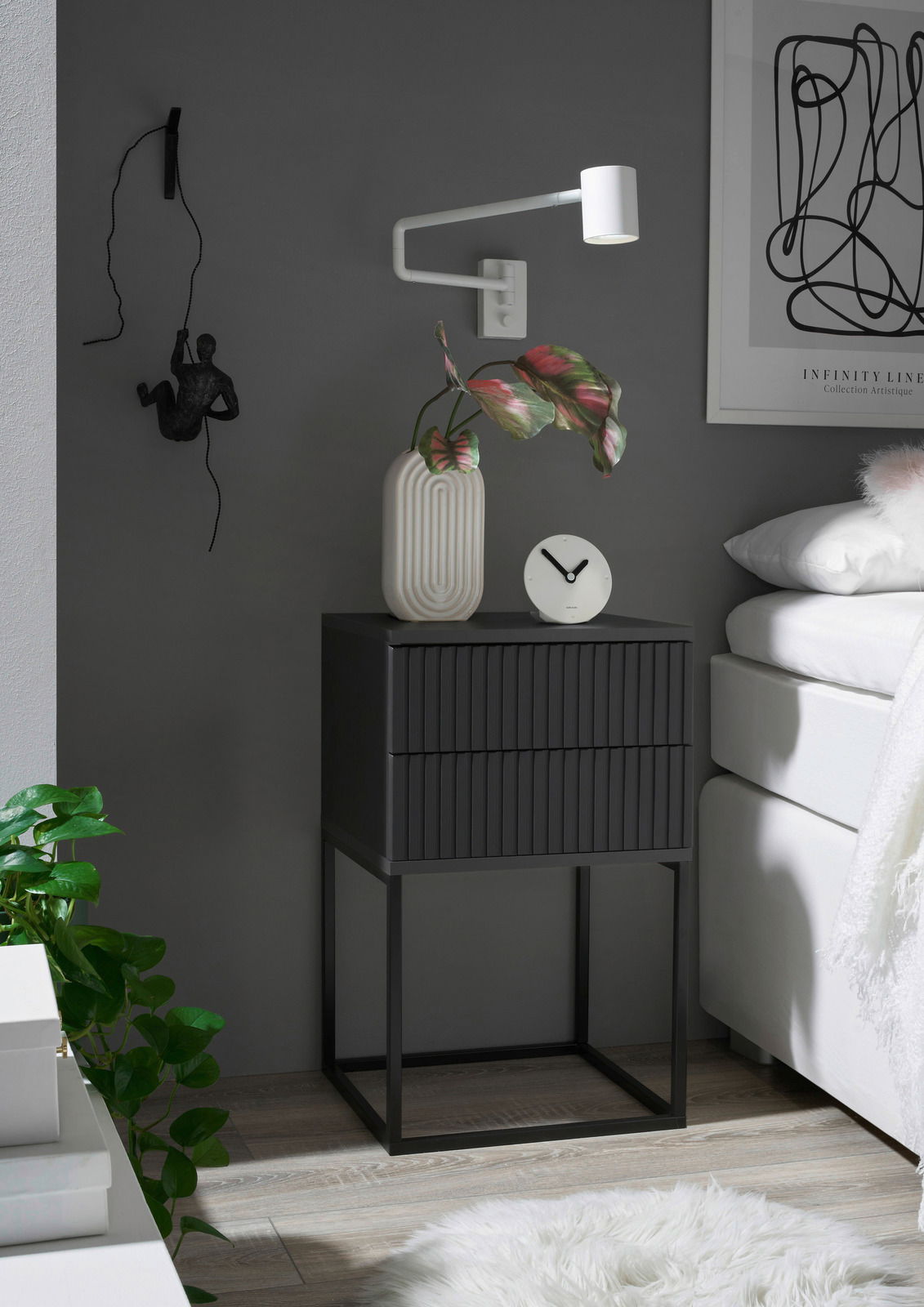 Moderne Nachtkommode in dunklem Design mit zwei Schubladen, dekoriert mit einer Vase und einer Uhr, seitliche Perspektive.