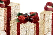 Dekorative Weihnachtsgeschenkboxen aus goldfarbenem Drahtgeflecht mit roten Glitzerbändern und Schleifen, Nahaufnahme in leicht erhöhter Frontalperspektive
