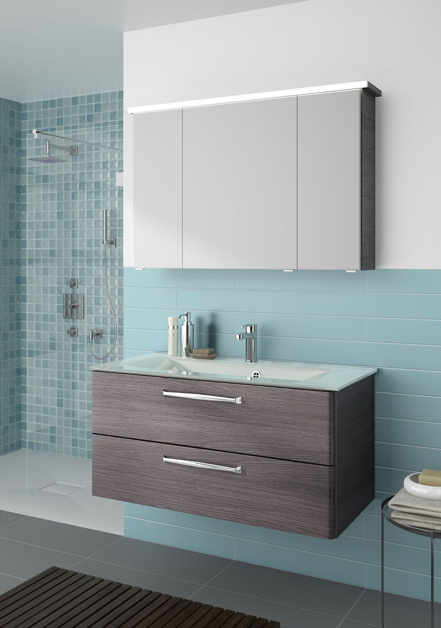 Moderner Badblock mit grauen Schubladen und integriertem Waschbecken, frontal betrachtet.